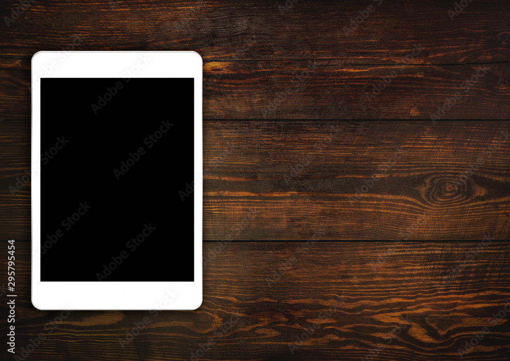 tablet on dark wooden table top view tablet on dark wooden table top view