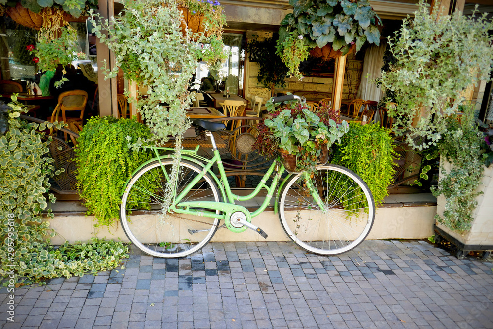Vintage green bicycle with basket full of flowers
