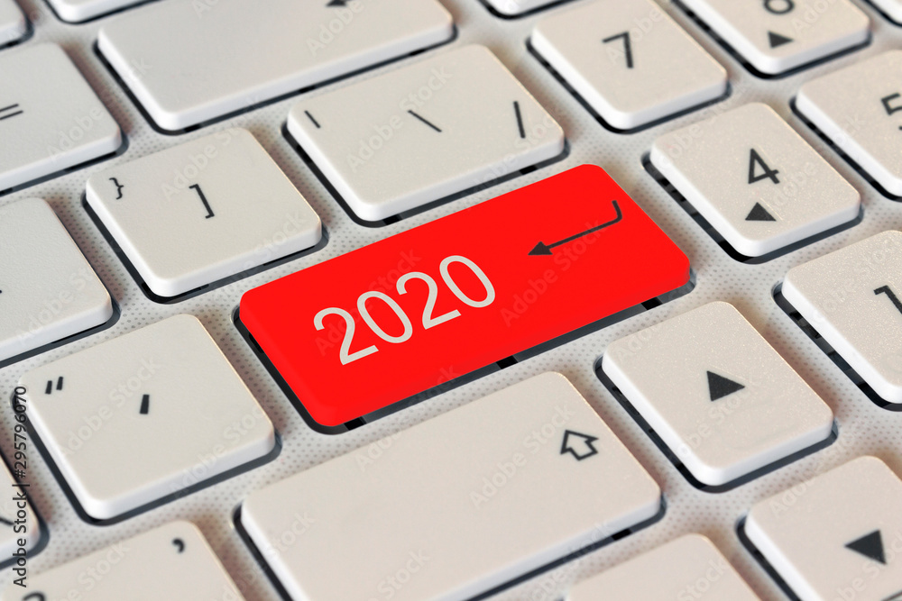 on the white keyboard a red button with the number 2020, the start of the new year on the white keyboard a red button with the number 2020, the start of the new year