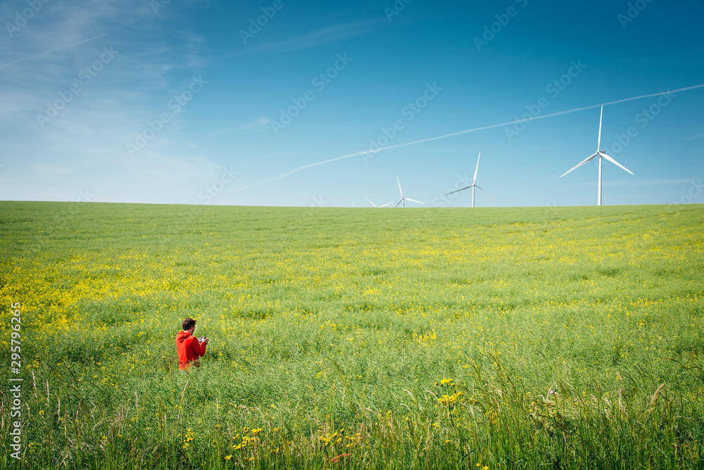 un homme dans un champ de colza photographie des éoliennes dans le ciel bleu un homme dans un champ de colza photographie des éoliennes dans le ciel bleu