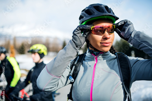 Mountain bikers standing on road outdoors in winter.