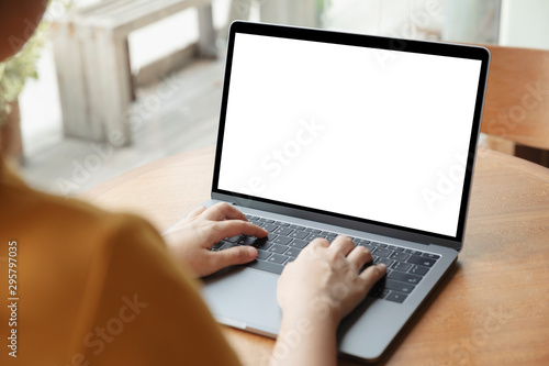 Women using laptop with blank screen at table in the office, Back view of business women hands busy using laptop at office desk.