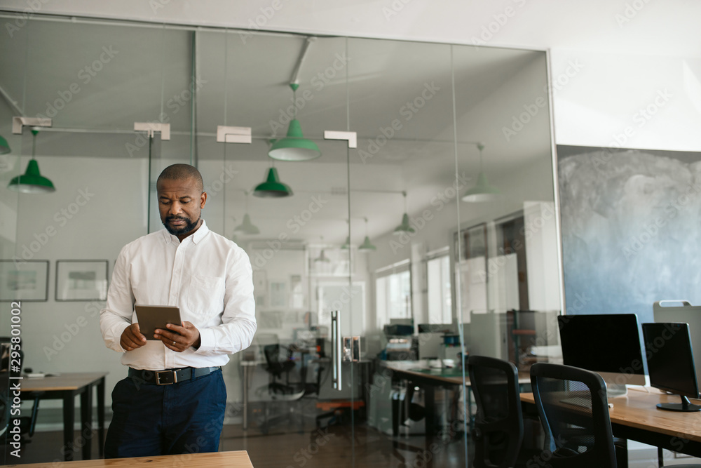 African American businessman working on a tablet in his office African American businessman working on a tablet in his office