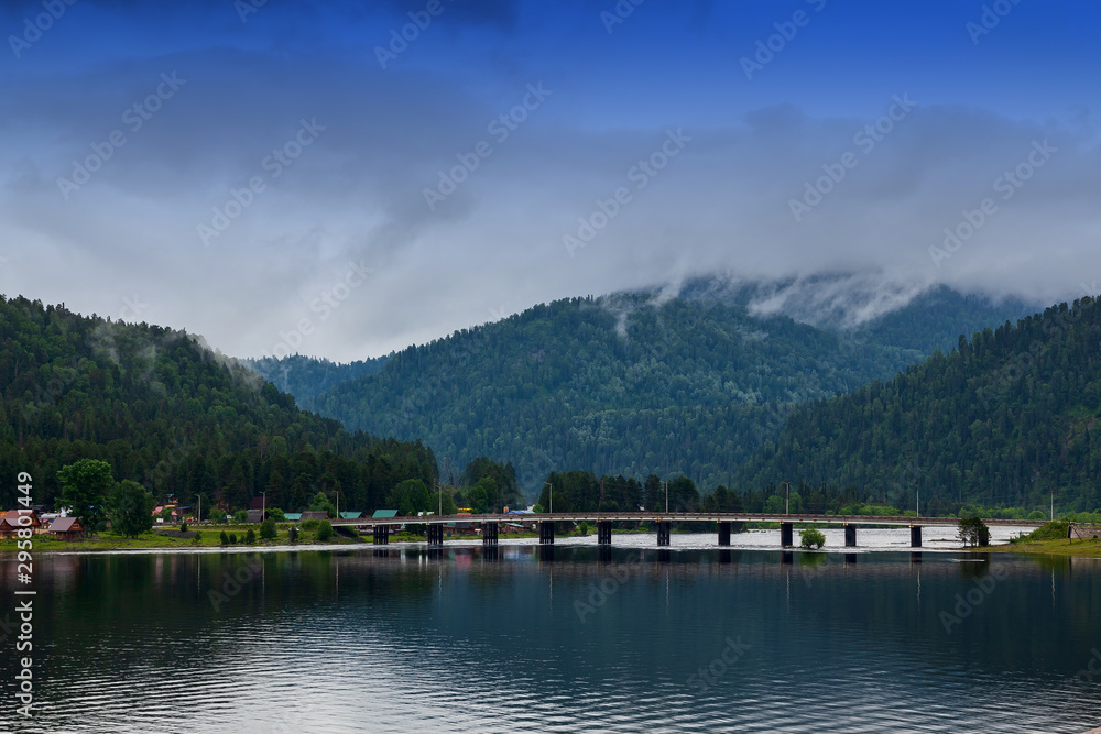 view of the road bridge connecting the two banks of the River on which the two villages of Iogach and Artybash are located at mouth of the Teletskoye Lake in Altai Mountains