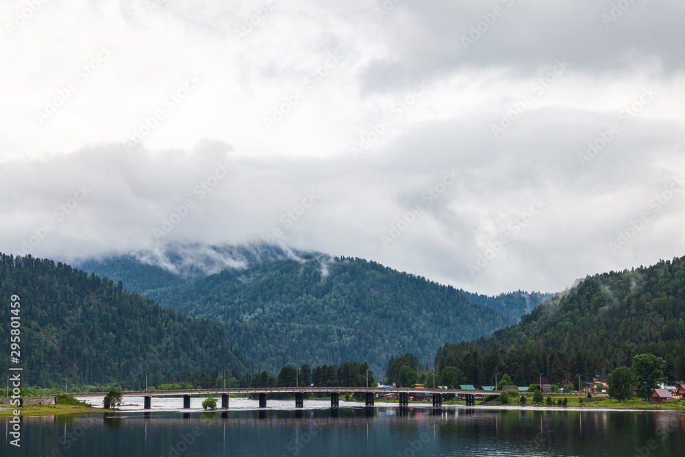 Fototapeta premium view of the road bridge connecting the two banks of the River on which the two villages of Iogach and Artybash are located at mouth of the Teletskoye Lake in Altai Mountains