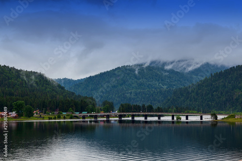 view of the road bridge connecting the two banks of the River on which the two villages of Iogach and Artybash are located at mouth of the Teletskoye Lake in Altai Mountains