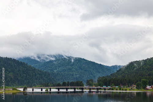 view of the road bridge connecting the two banks of the River on which the two villages of Iogach and Artybash are located at mouth of the Teletskoye Lake in Altai Mountains © Aleksandr Kondratov