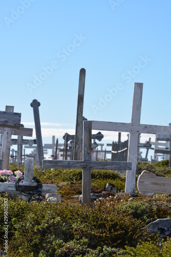 Greenland, Ilulissat, July - graveyard with crosses in the greenlandic tundra - blue sky in the Disko Bay 