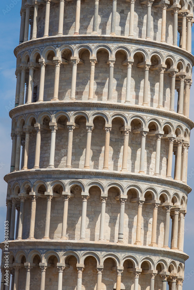 Fragment of a leaning tower of Pisa against a blue sky