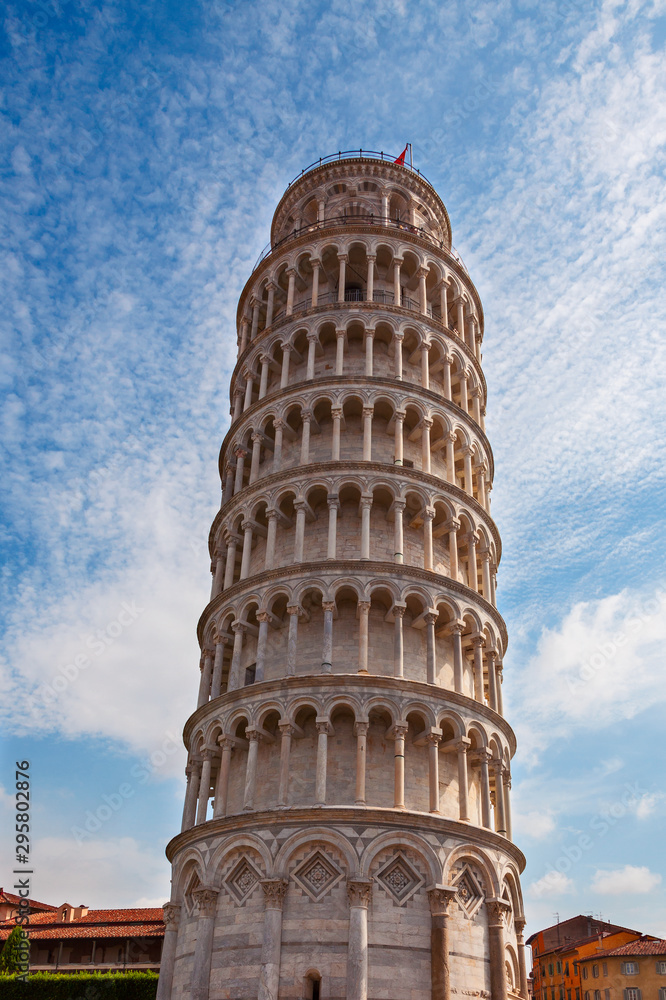 Leaning tower of pisa against the blue sky in light clouds
