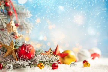 Christmas winter background with gift box, Christmas baubles and fir tree branches on snow.