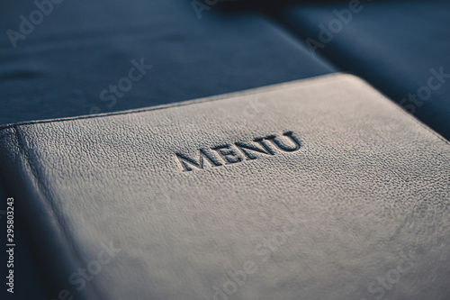 Dark blue menu book on table in restaurant, selective focus photo