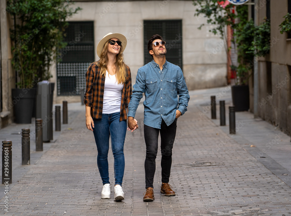 Naklejka premium Młoda para zakochanych spaceru po ulicy na romantyczną wycieczkę