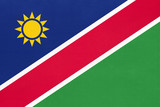 Republic of Namibia national fabric flag, textile background. Symbol of african world country.
