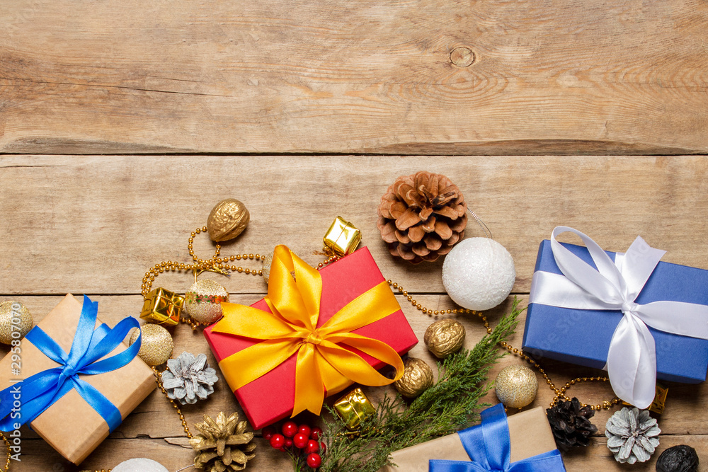 Gifts and Christmas decorations, Christmas tree branch on a wooden background. The concept of Christmas, winter holidays, new year. Flat lay, top view Gifts and Christmas decorations, Christmas tree branch on a wooden background. The concept of Christmas, winter holidays, new year. Flat lay, top view
