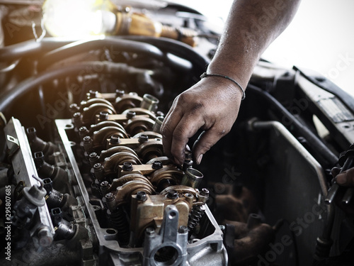 Auto mechanic working in garage. Remove the cover part. Authentic close-up