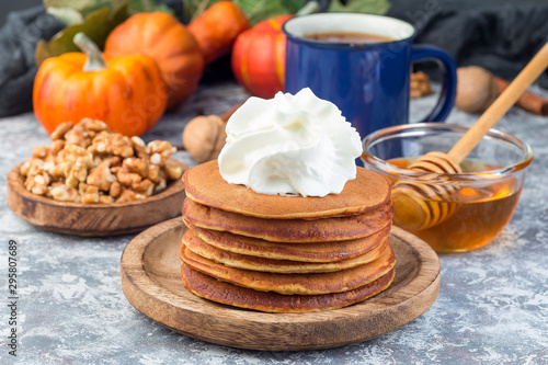 Fotografie, Obraz Delicious homemade pumpkin pancakes served with whipping cream, walnuts and hone