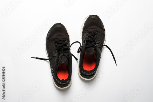 Old, worn sneakers with holes on a white background. Concept of running, marathon, ultramarathon, long workout. Flat lay, top view