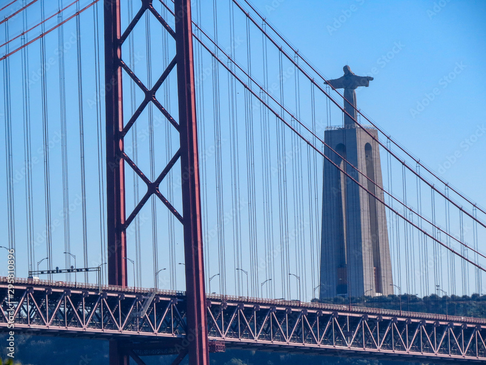 Christ the King Statue and the 25th April Bridge in Lisbon, Portugal. Famous landmark on river Tagus.