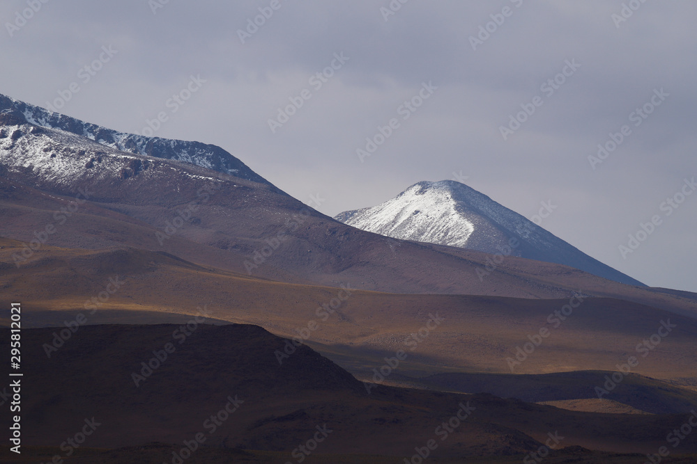 Snow-capped volcanoes and desert landscapes in the highlands of Bolivia. Andean landscapes of the Bolivia Plateau