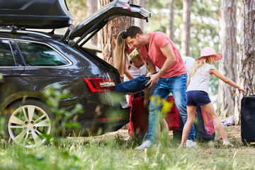 Family at the car while loading with luggage