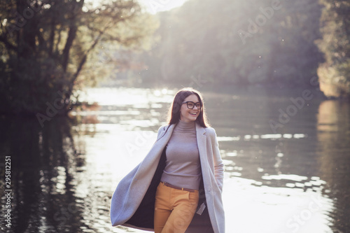 portrait of a happy brunette woman in autumn Park near the river