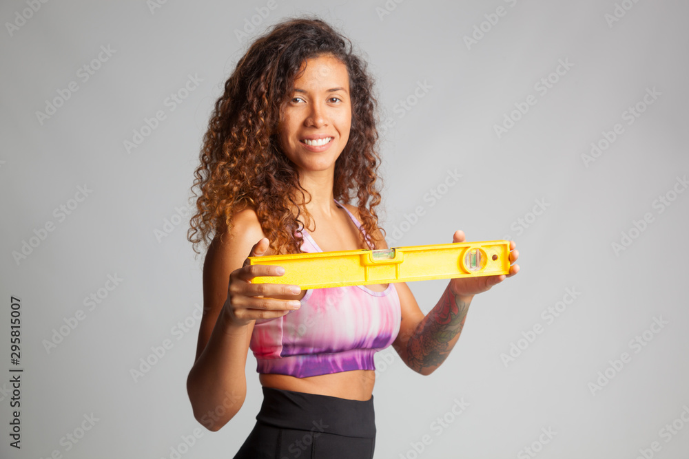 Chica joven deportista jugando con un nivel o aprendiendo a utilizarlo Chica joven deportista jugando con un nivel o aprendiendo a utilizarlo