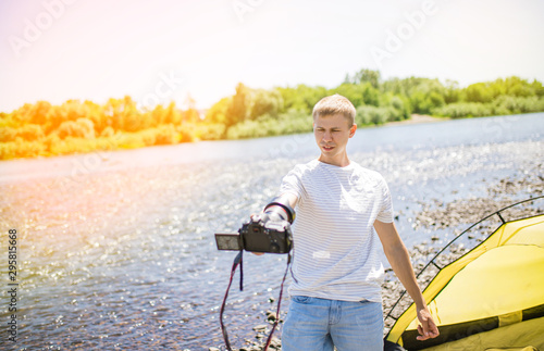 take pictures of yourself in nature. a man takes a selfie in nature. Photographer. Hobbies in nature. rest near the river, selfie