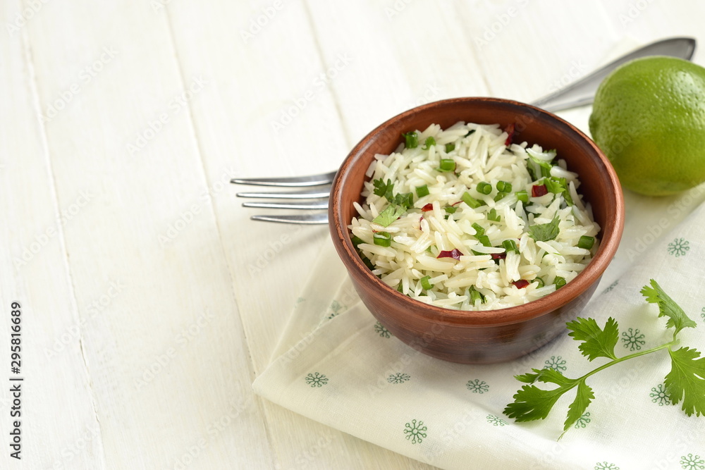 Basmati rice with lime, cilantro and garlic in ceramic bowl, copy space Basmati rice with lime, cilantro and garlic in ceramic bowl, copy space