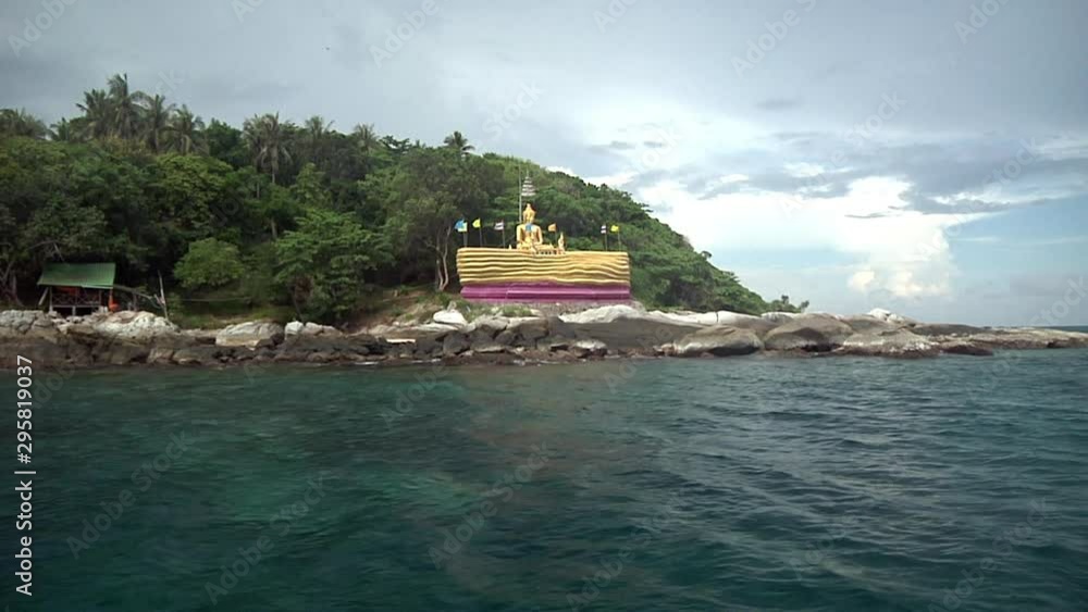 Going Past Gold Buddha Statue By Shoreline On Boat In Phuket, Thailand Going Past Gold Buddha Statue By Shoreline On Boat In Phuket, Thailand
