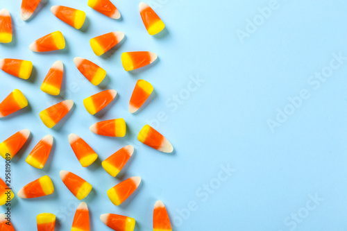 Bunch of candy corn sweets as sybol of Halloween hoiday on textured background with a lot of copy space for text. Flat lay composition for all hallows eve. Top view shot. photo