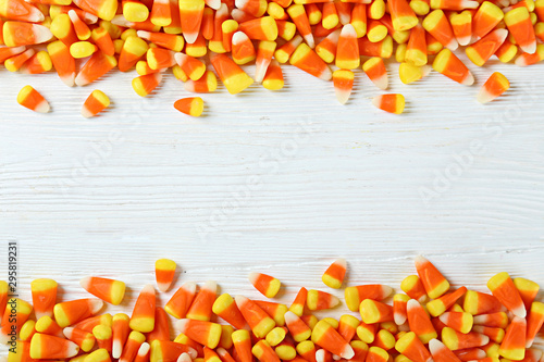 Bunch of candy corn sweets as sybol of Halloween hoiday on textured background with a lot of copy space for text. Flat lay composition for all hallows eve. Top view shot. photo