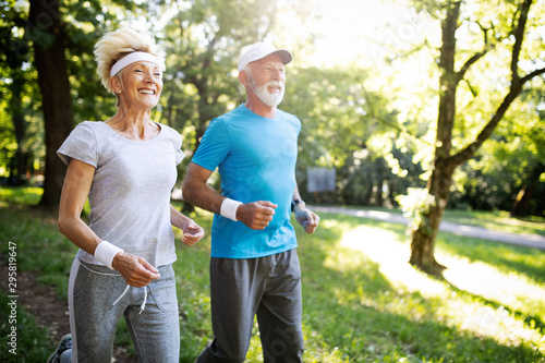 Beautiful mature couple jogging in nature living healthy
