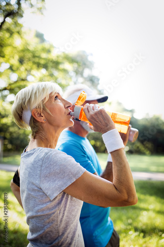 Fototapeta Naklejka Na Ścianę i Meble -  Mature or senior couple doing sport outdoors, jogging in a park