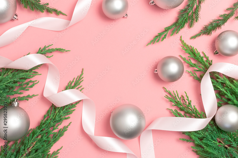 Frame from Silver Christmas toy balls, holiday ribbons, christmas tree branches on pink background. Flat lay top view copy space. New Year's composition, winter decoration. Minimal celebration concept Frame from Silver Christmas toy balls, holiday ribbons, christmas tree branches on pink background. Flat lay top view copy space. New Year's composition, winter decoration. Minimal celebration concept