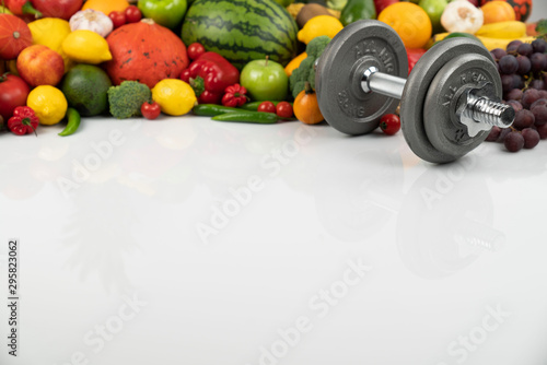 Fitness concept – healthy nutrition and equipment for fitness exercises on the white background. 