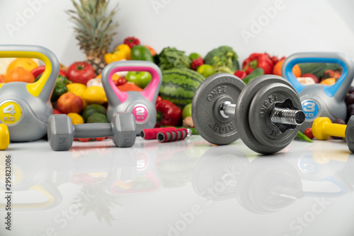 Fitness concept – healthy nutrition and equipment for fitness exercises on the white background. 