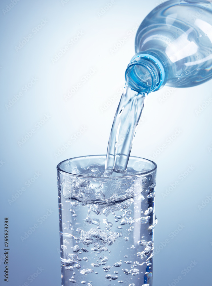 pouring water from plastic bottle into glass pouring water from plastic bottle into glass