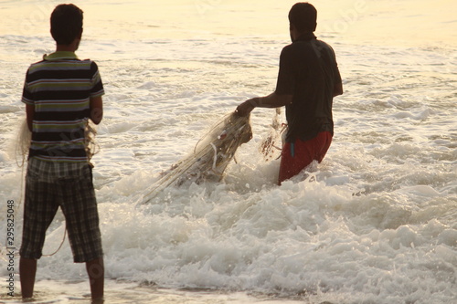 Two fisherman's capture fish / fishing using with fish net in Chennai besant nagar Elliot's beach on the early morning photo