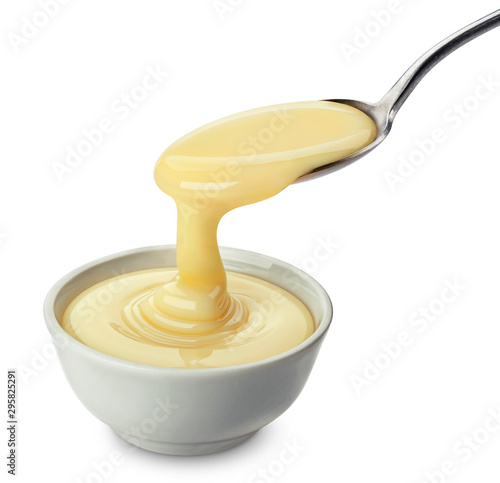 Pouring condensed milk isolated on white background