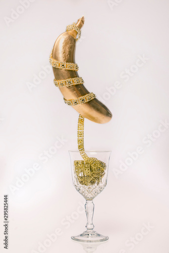 Golden banana on glass cup