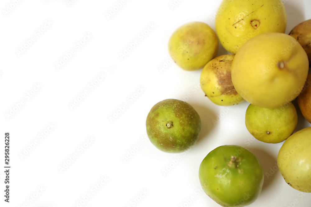 fresh and green lemon with tainted lemon on a white background fresh and green lemon with tainted lemon on a white background