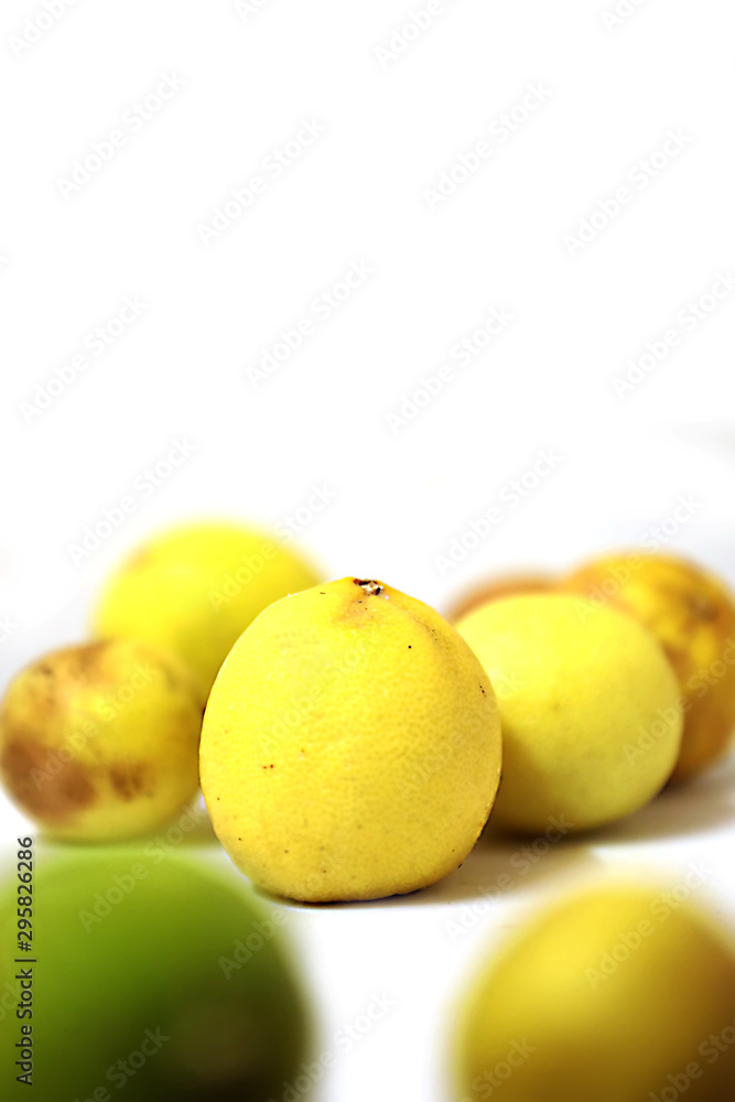 fresh and green lemon with tainted lemon on a white background