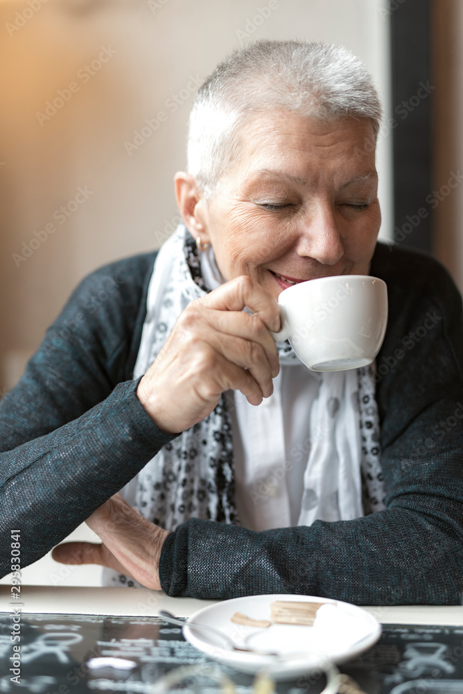 Old lady enjoying her coffee aroma, sitting at the coffee shop Old lady enjoying her coffee aroma, sitting at the coffee shop