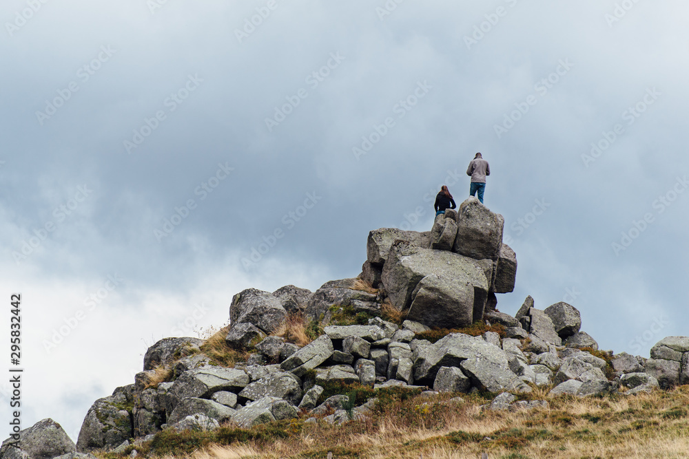 un couple sur des rochers observant le paysage. Des gens sur des rochers à la montagne. Des personnes grimpant sur des rochers.