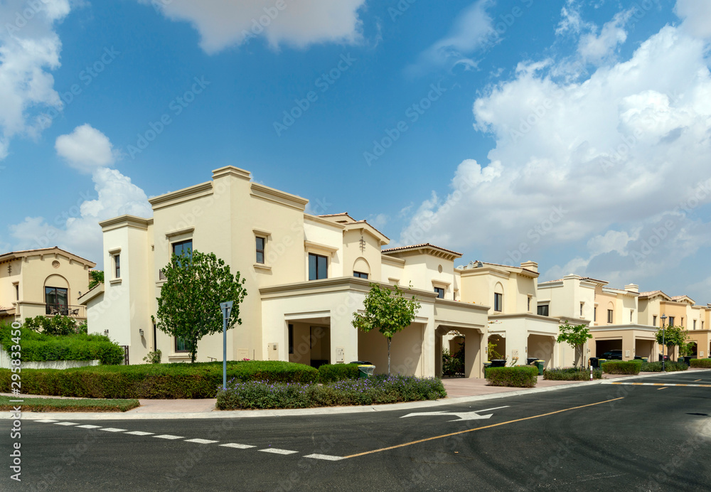 Luxury villa compound housing development with beautiful blue sky with white clouds Luxury villa compound housing development with beautiful blue sky with white clouds