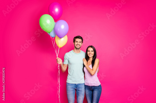 Photo of charming guy and lady couple holding air balloons in hands came to parents birthday party wear casual outfit isolated pink color background