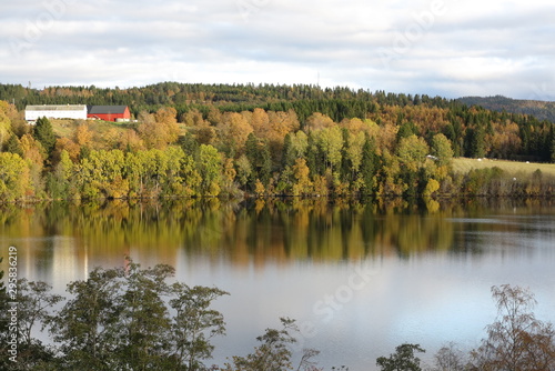 Autumn landscape of mountain and lake, with the colorful trees, symmetric reflection in the clean water
