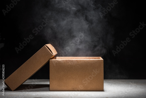 opened mystery box with smoke float up on dark background photo