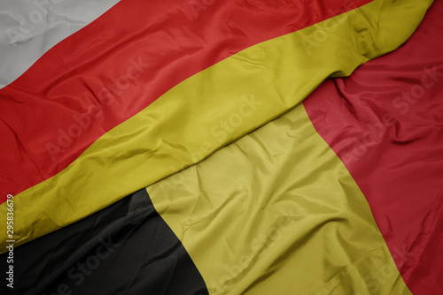 waving colorful flag of belgium and national flag of south ossetia.